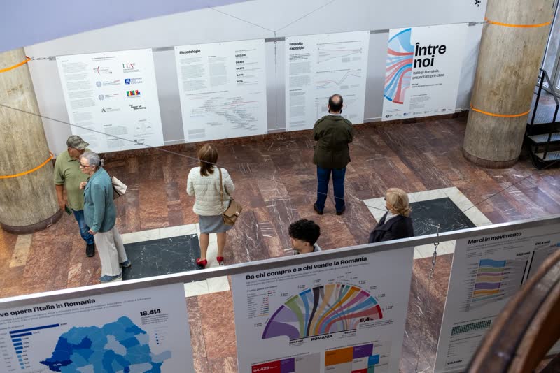 Seen from the balcony, visitors read the opening wall across a marble floor.
